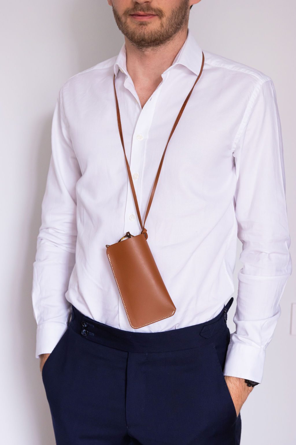 Étui cognac porté sur une chemise blanche