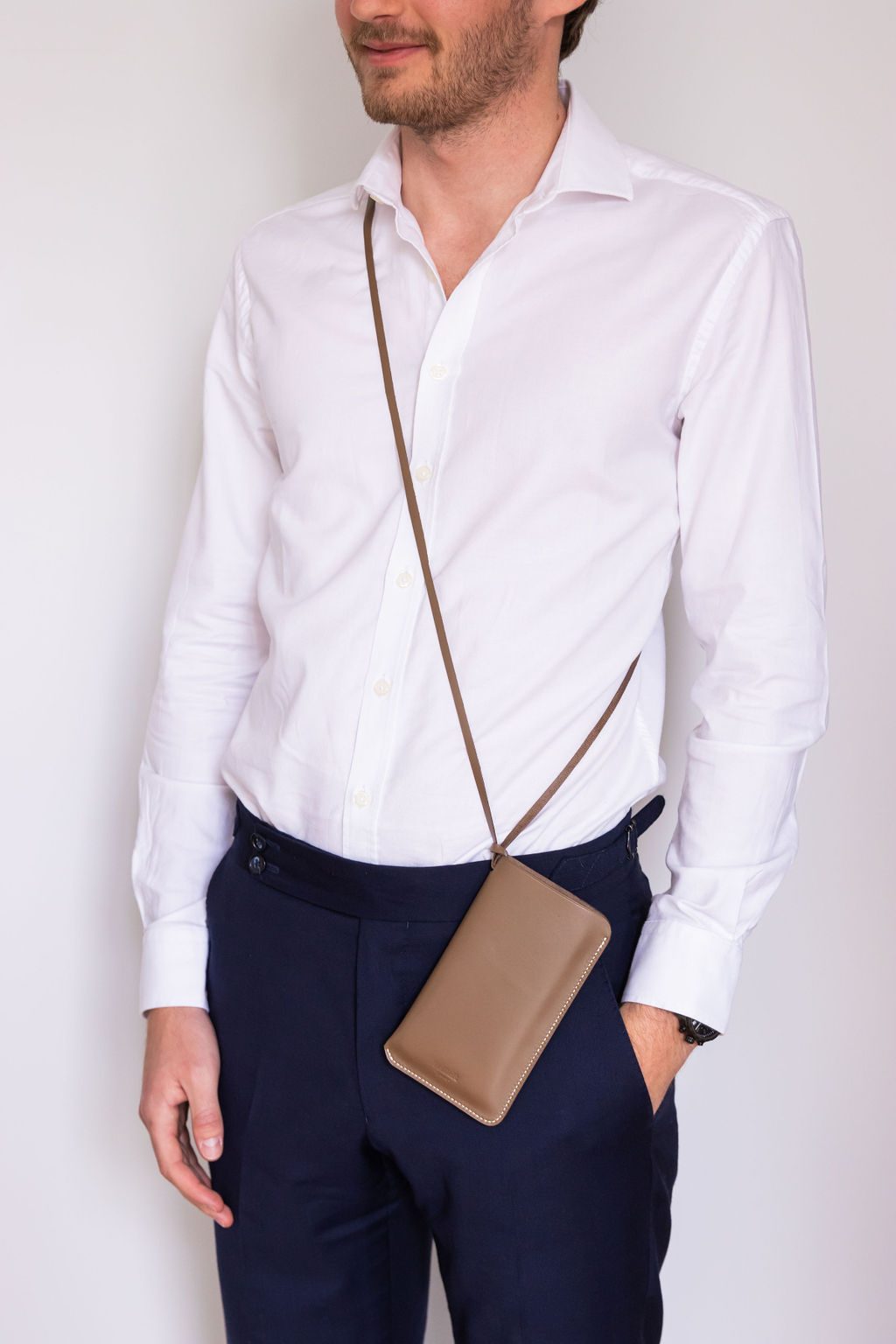 Étui taupe porté sur une chemise blanche